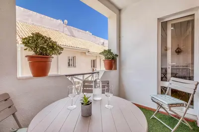 a table on a balcony with wine glasses on it at T2 duplex na Marina de Vilamoura in Loulé