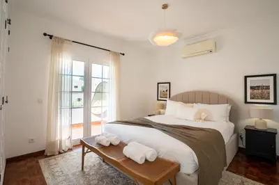 a bedroom with a bed and a table with towels on it at Luxurious Villa - Pool, Hot Tub, Cinema and Golf in Vilamoura