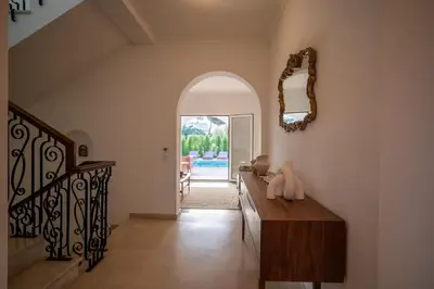 a living room with a wooden table and a mirror at Luxurious Villa - Pool, Hot Tub, Cinema and Golf in Vilamoura