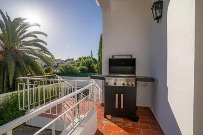 a kitchen with a stove on a balcony at Luxurious Villa - Pool, Hot Tub, Cinema and Golf in Vilamoura