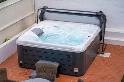 a hot tub sitting on top of a patio at Luxurious Villa - Pool, Hot Tub, Cinema and Golf in Vilamoura