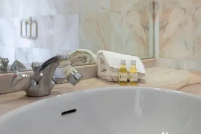a bathroom sink with a bath tub with two bottles of soap at TAC - Windmill OceanFront Villa in Albufeira