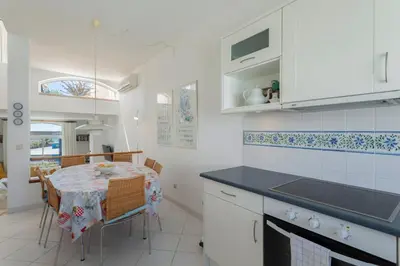 a kitchen with a table and a dining room at TAC - Windmill OceanFront Villa in Albufeira