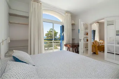 a white bedroom with a bed and a window at TAC - Windmill OceanFront Villa in Albufeira
