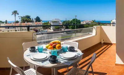 a table with a bowl of fruit on a balcony at white T1 - Ocean View in Albufeira