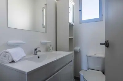a white bathroom with a sink and a toilet at white T1 - Ocean View in Albufeira