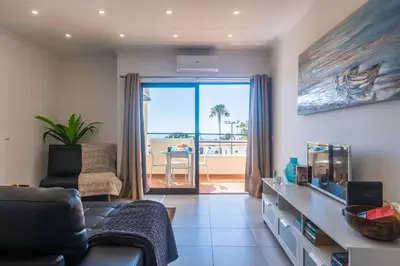 a living room with a couch and a view of the ocean at white T1 - Ocean View in Albufeira