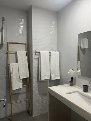 a bathroom with a sink and a mirror and towels at Casa MarRia in Faro
