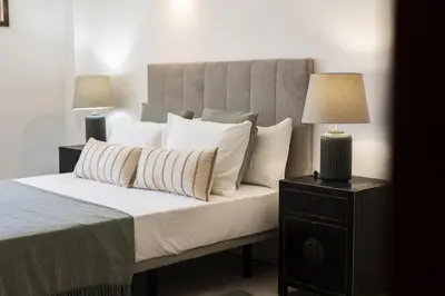 a bedroom with a bed with white pillows and two lamps at Oasis apartment - City center by HD in Faro