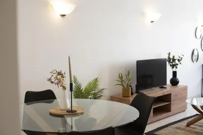 a dining room with a table and chairs and a tv at Oasis apartment - City center by HD in Faro