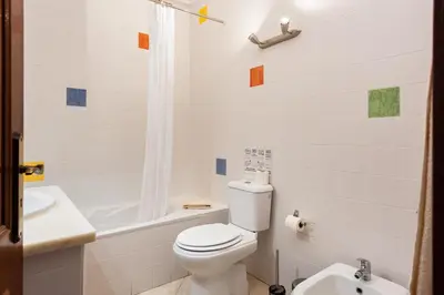 a white bathroom with a toilet and a sink at Oasis apartment - City center by HD in Faro