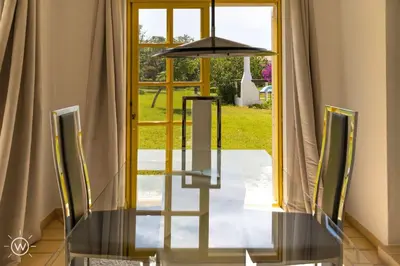 a glass table and chairs in front of a door at Sunshine Villa Salgados Guia Algarve in Albufeira