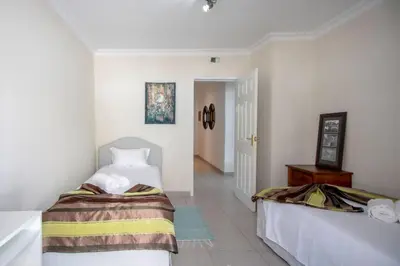 a bedroom with two beds and a hallway at Villa Le petit charme in Albufeira