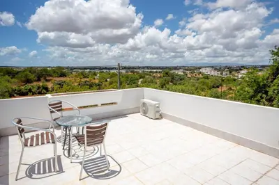 a patio with a table and chairs on a balcony at Villa Le petit charme in Albufeira