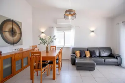 a living room with a table and a couch at Villa Le petit charme in Albufeira