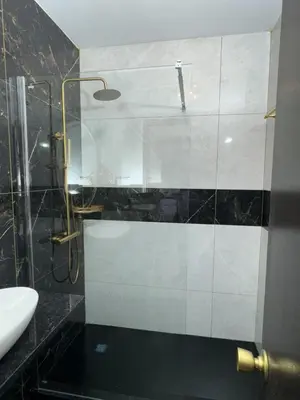 a bathroom with a glass shower and a sink at Magna Oura in Albufeira