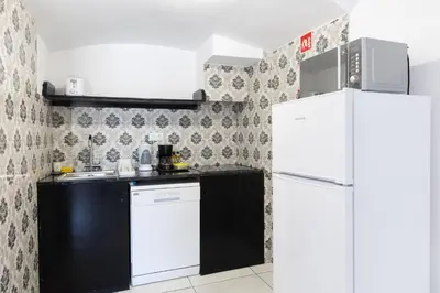 a kitchen with white appliances and a white refrigerator at Magna Oura in Albufeira