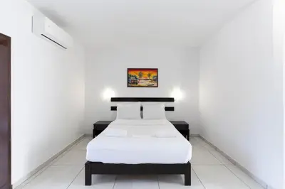 two beds in a room with white walls at Magna Oura in Albufeira