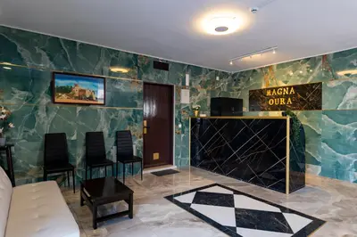 a lobby with green walls and a white couch and chairs at Magna Oura in Albufeira