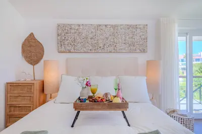 a bed with a tray of fruit on it at 5 star Luxury SevenPines apartment with large balcony and 3 communal pool in Quarteira