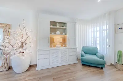 a living room with a blue chair and a cabinet at 5 star Luxury SevenPines apartment with large balcony and 3 communal pool in Quarteira