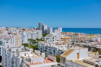 a view of a city with white buildings and the ocean at 2bdr Sea View Miravila Apartment in Quarteira in Quarteira