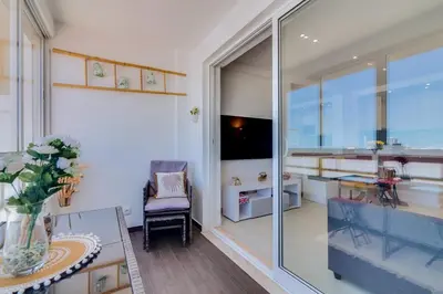 a living room with a glass door and a table and a chair at 2bdr Sea View Miravila Apartment in Quarteira in Quarteira