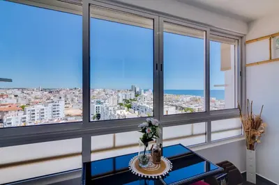 a room with windows and a table with flowers at 2bdr Sea View Miravila Apartment in Quarteira in Quarteira