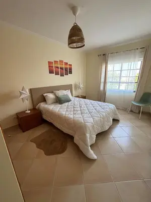 a bedroom with a large bed and a window at T3 - Casa Jerome in Quarteira