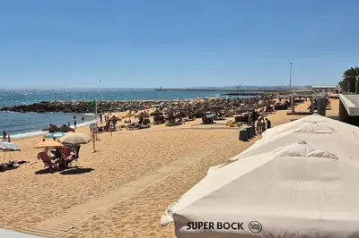 a beach with a lot of umbrellas and people on it at T3 - Casa Jerome in Quarteira