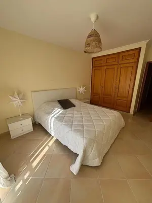 a bedroom with a bed with a white comforter at T3 - Casa Jerome in Quarteira