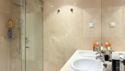 a bathroom with two sinks and a shower at Refúgio Sereno Vilamoura T2 by HsR Vilamarina in Quarteira