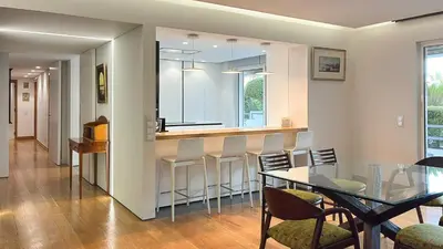a kitchen with a bar and a table and chairs at Refúgio Sereno Vilamoura T2 by HsR Vilamarina in Quarteira