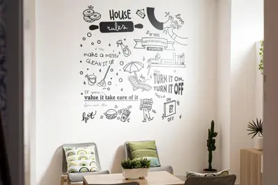 a living room with a wall with doodles on it at Madalena Hostel e Suites in Faro