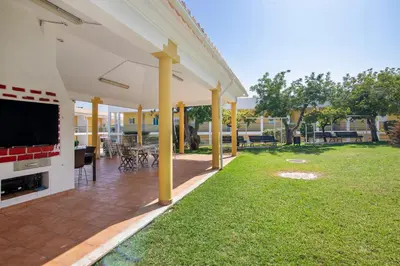 an outdoor patio with a television and a lawn at Encosta São José in Guia