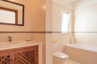 a bathroom with a sink and a toilet and a mirror at Villa Água in Albufeira