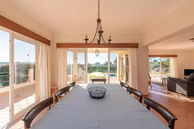 a dining room with a long table and chairs at Villa Água in Albufeira