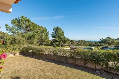 a garden with a stone wall and a yard at Villa Costa in Albufeira