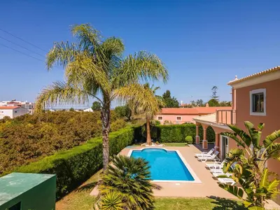 a villa with a swimming pool and a palm tree at Villa Hunês in Guia