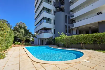 a swimming pool in front of a building at Apartment with 2 bedrooms at Vilamoura Marina in Quarteira