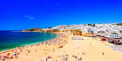 two beds in a room with blue sheets at Casa Estrela do Mar in Albufeira