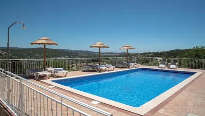 a pool on a balcony with umbrellas and chairs at Casa Quadra Dique in Faro
