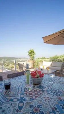 a table with a bowl of watermelon and a bottle of wine at Casa Quadra Dique in Faro