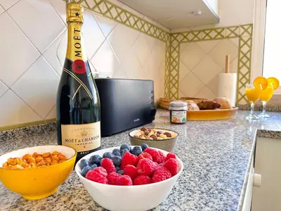 a bottle of wine and a bowl of fruit on a counter at Ocean Breeze WindMill Condo by BeCherish in Albufeira