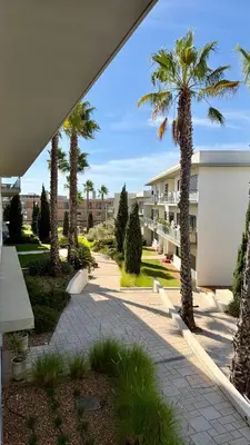 a courtyard with palm trees and a building at Cavalo Preto Beach Resort in Quarteira