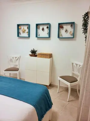 a bedroom with a bed and two chairs at T2 Falésia - Olhos de Água in Olhos de Água