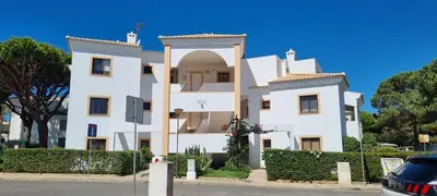 a white building with an arch in front of it at T2 Falésia - Olhos de Água in Olhos de Água
