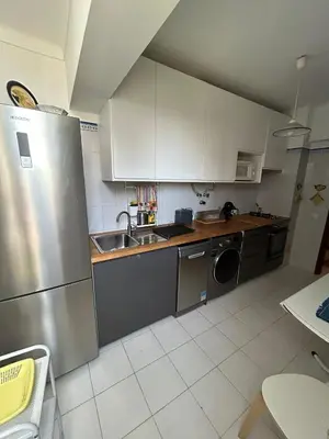 a kitchen with a stainless steel refrigerator and a dishwasher at Nice Flat in Quarteira Beach in Quarteira
