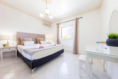 a bedroom with a bed and a desk and a window at Villa Paloma by Algarve Vacation in Albufeira