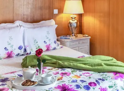 a bed with a green blanket and a tray of food on it at Sea View Downtown - Albufeira in Albufeira
